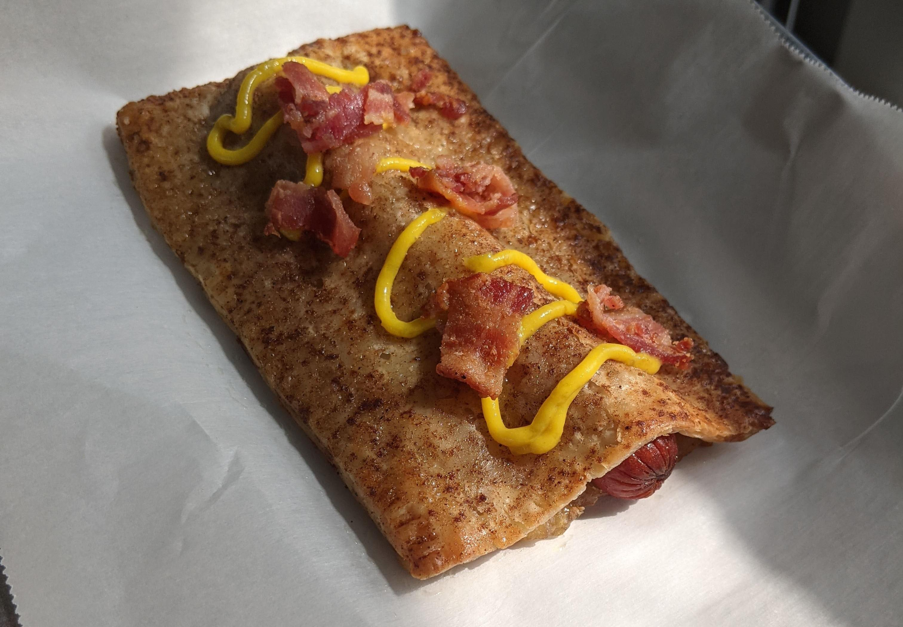 Apple Pie Hot Dog sitting in sunbeam on parchment paper