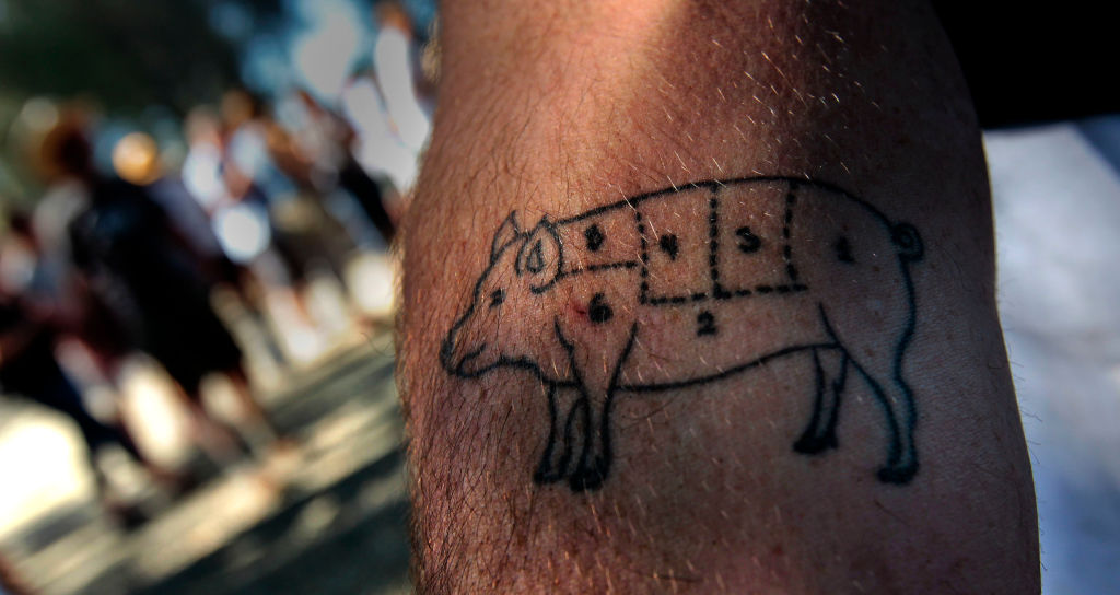 Tattoo of pig diagram on someone's forearm