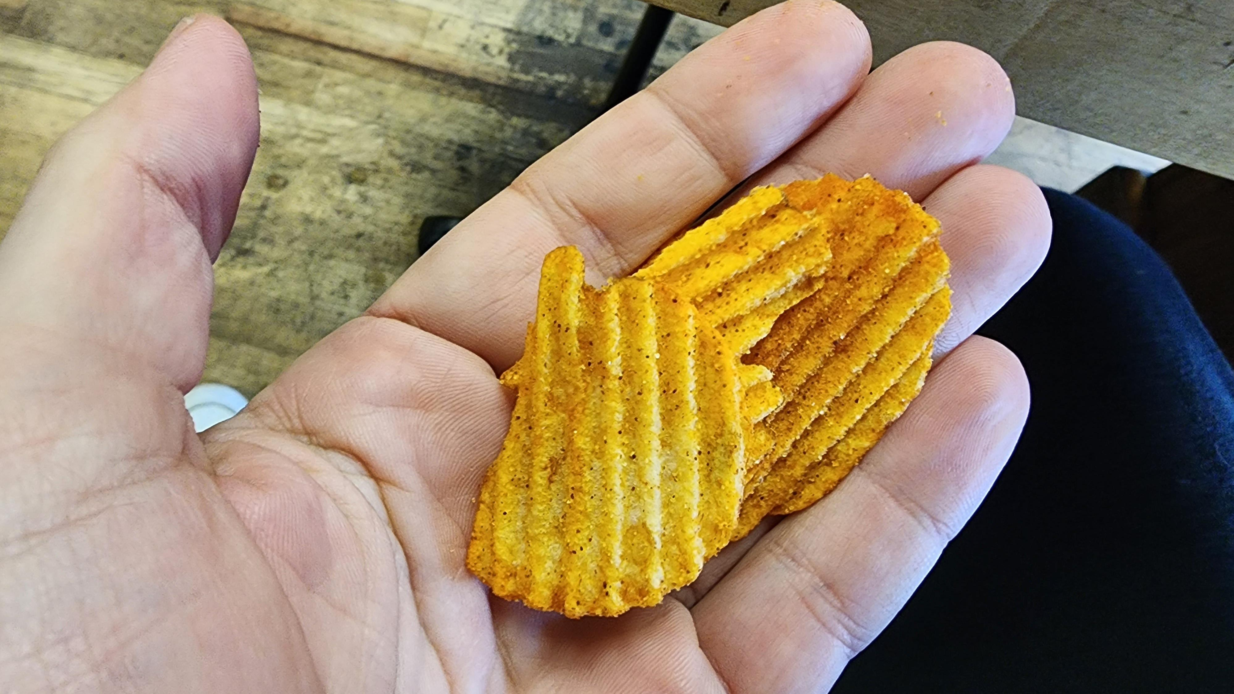 Handful of Old Vienna Cheesy Red Hot Riplets chips