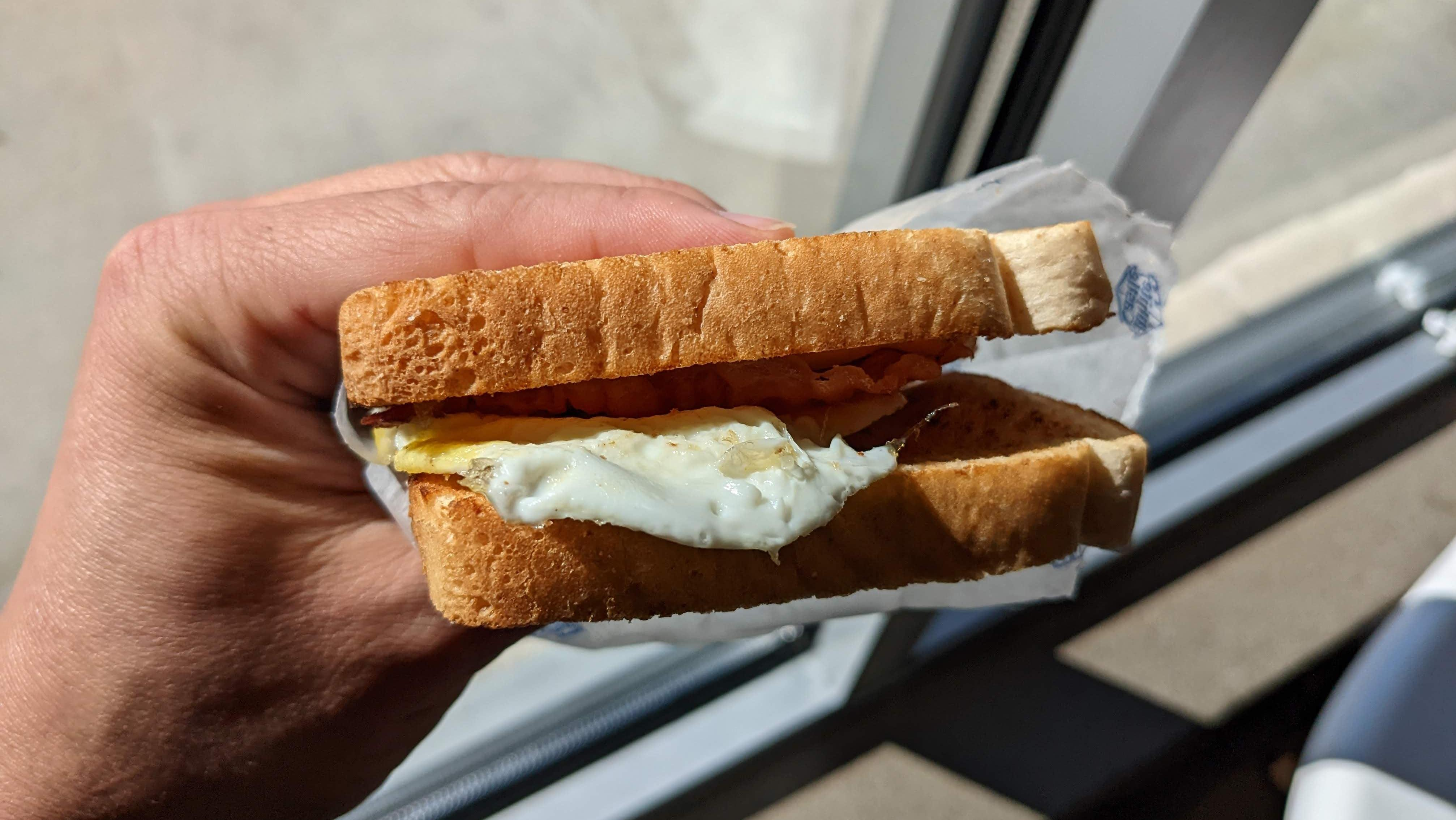 hand holding breakfast sandwich