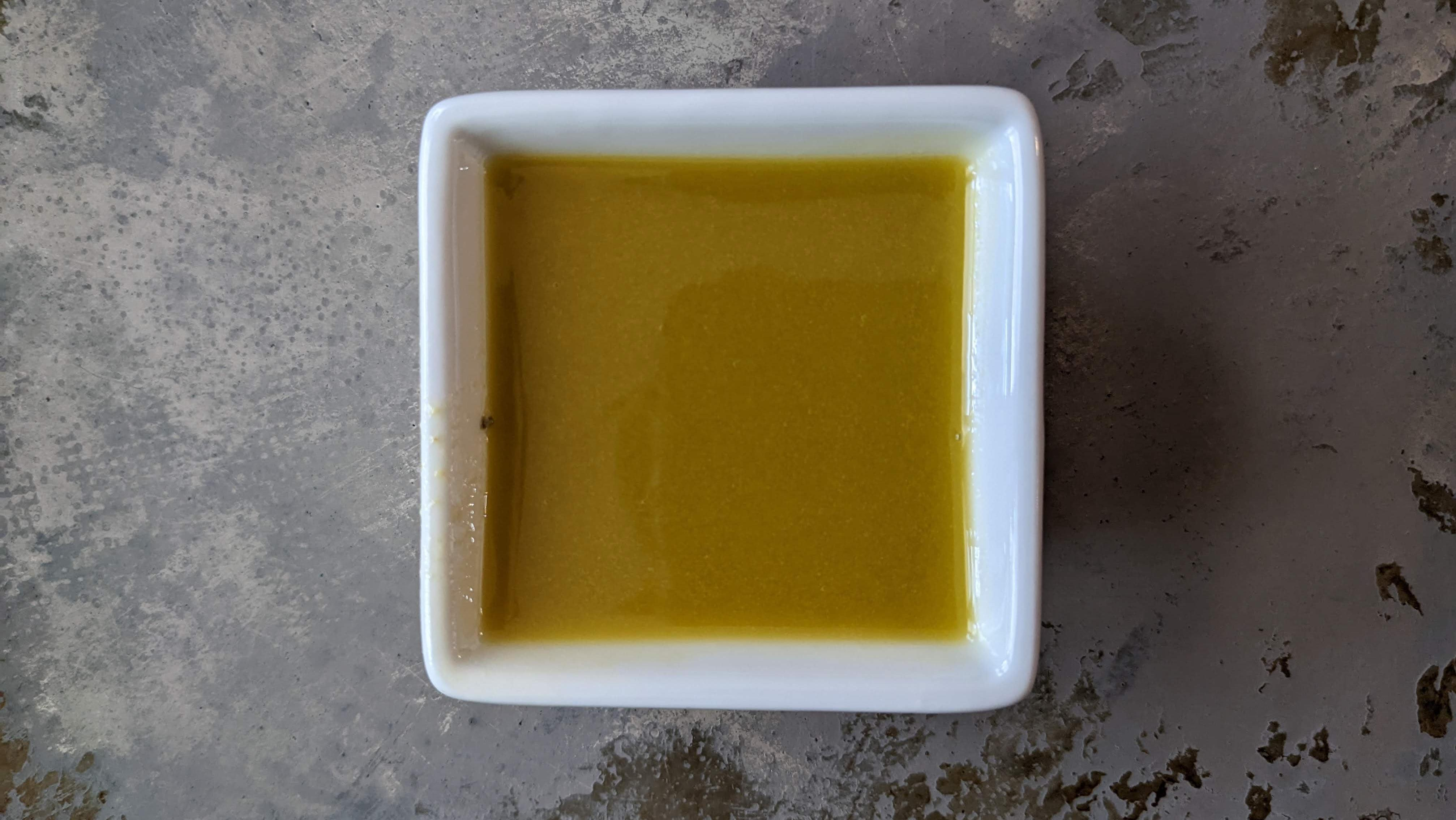 Dijon Mustard Giardiniera Oil Vinaigrette in cup, with slightly olive color