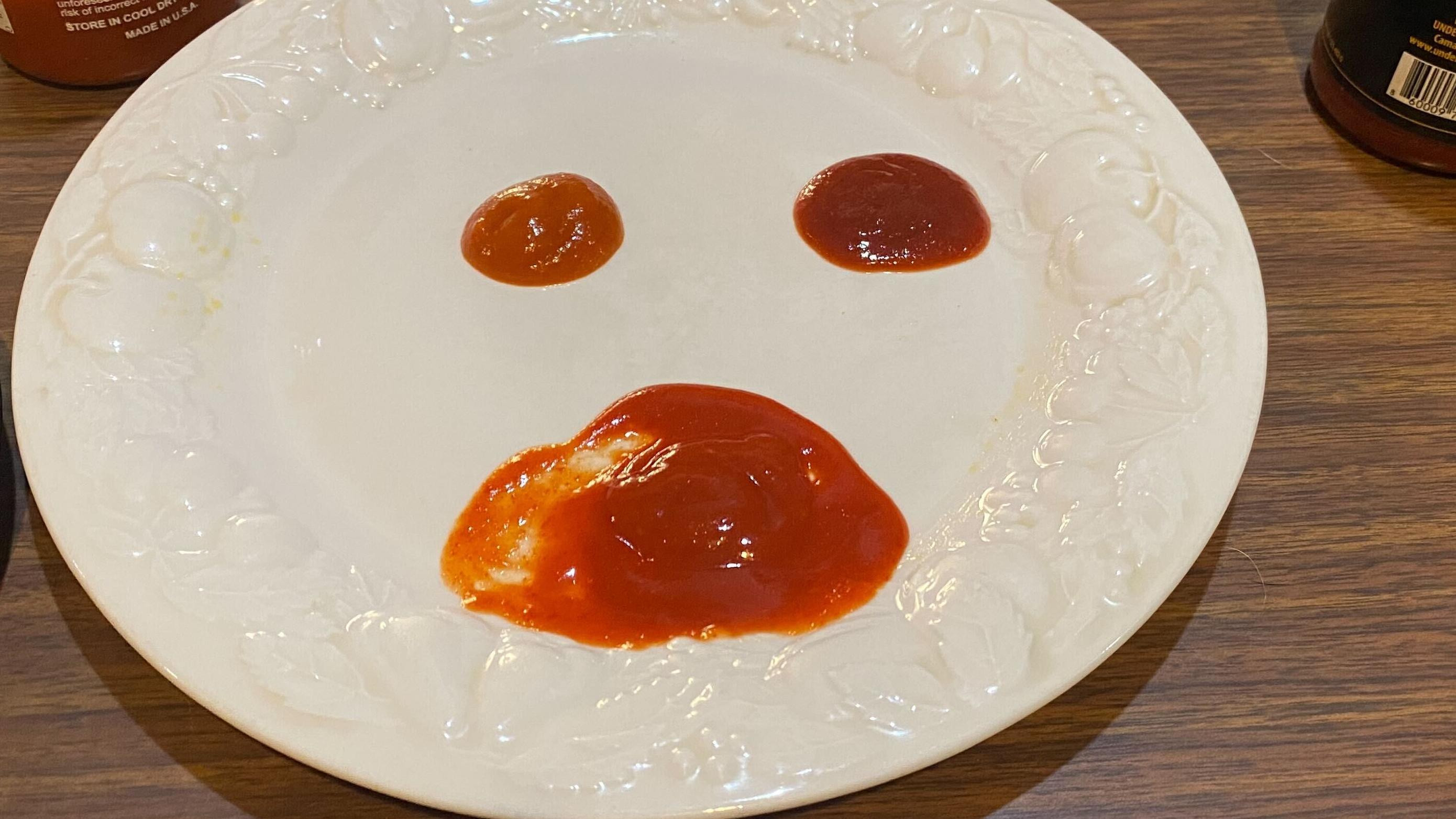 Three sriracha hot sauces on a plate, each a different color