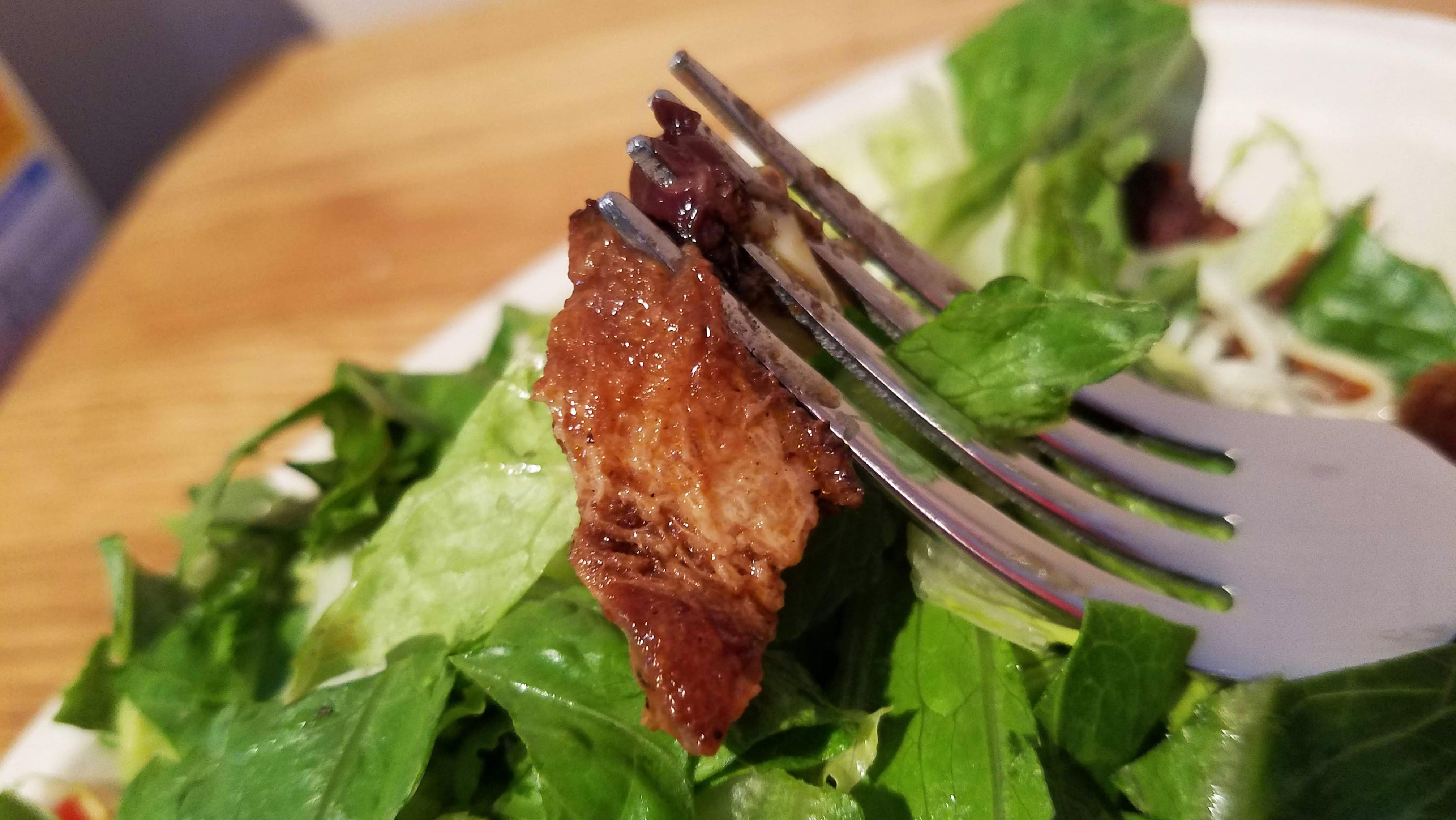 Chipotle brisket close up, hanging from fork tines