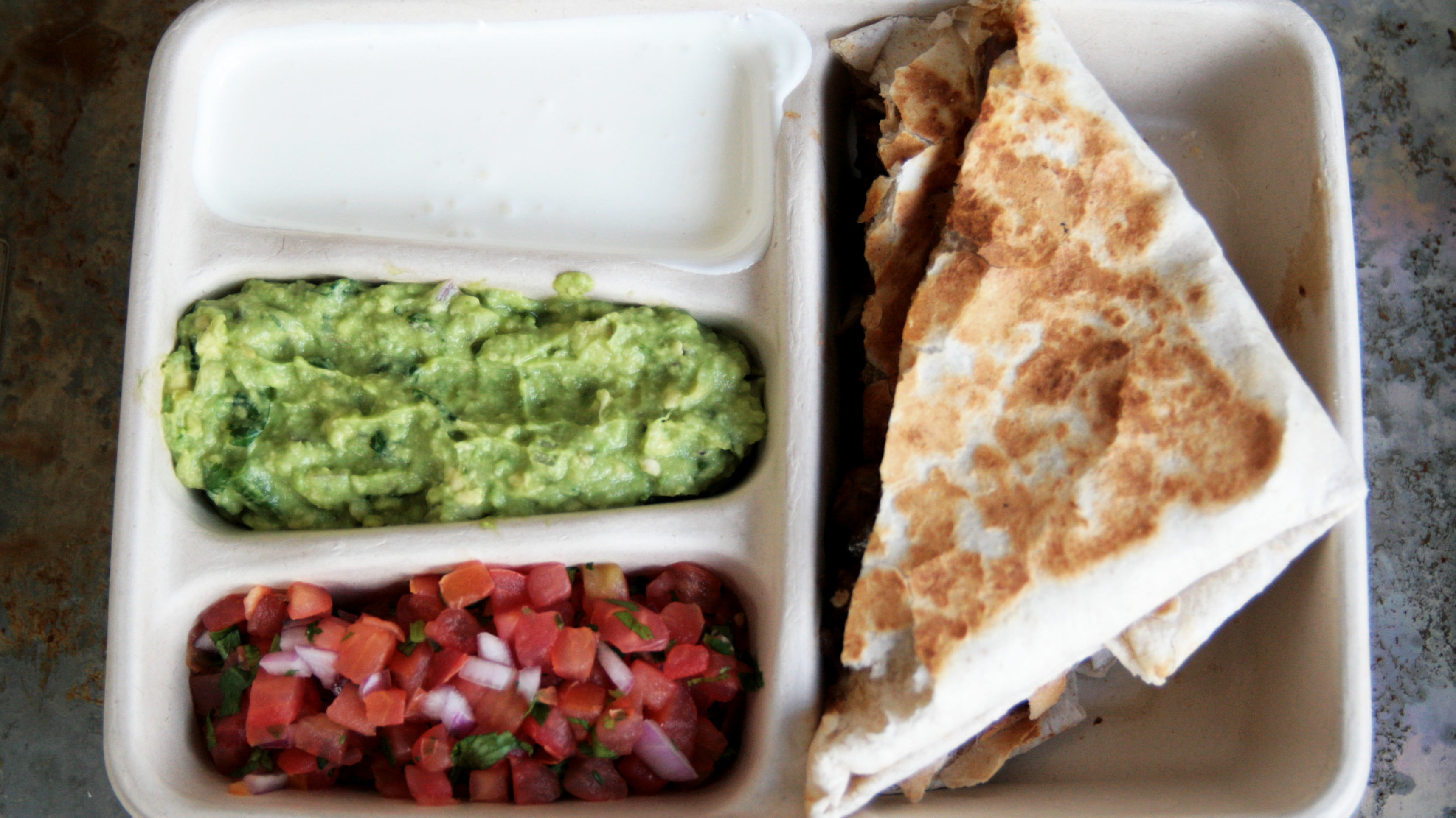 aerial view of quesadilla tray with cups for salsa, guacamole, and sour cream