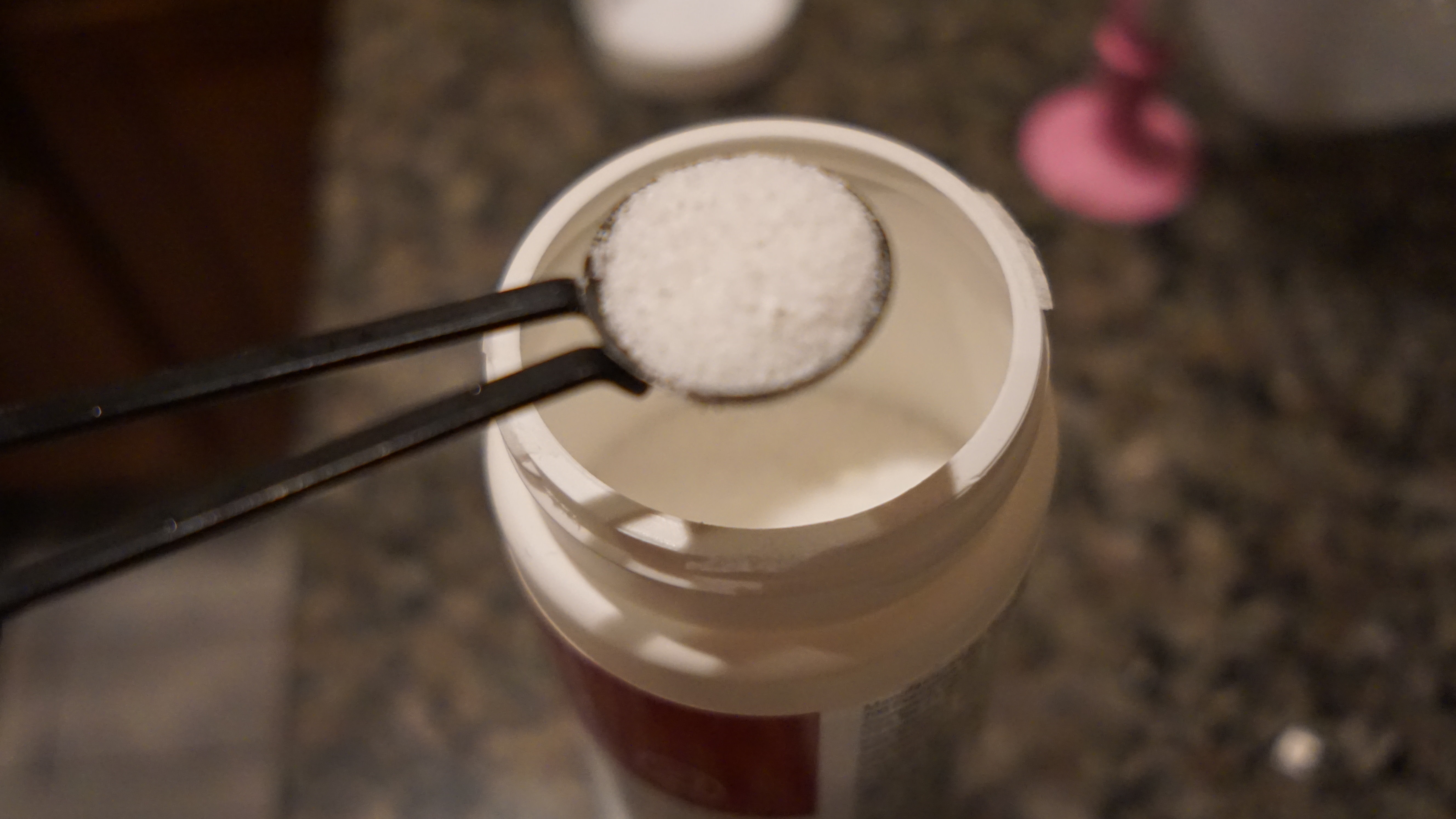 Close-up of a spoonful of white Cafiza powder