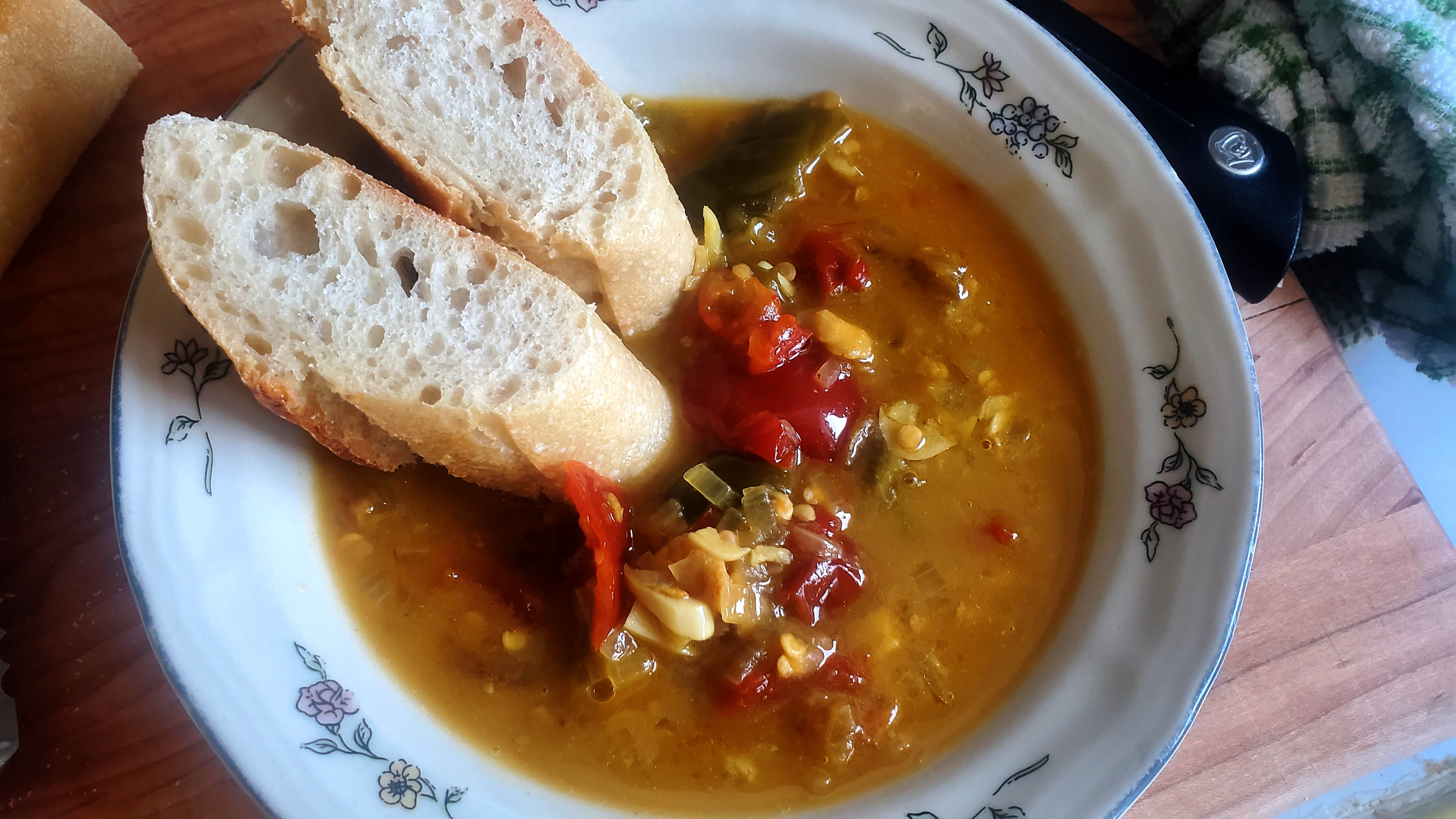 A bowl of chiff choff sauce with two slices of crusty bread sitting on the rim