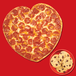 Heart-shaped pizza with plate of cookies