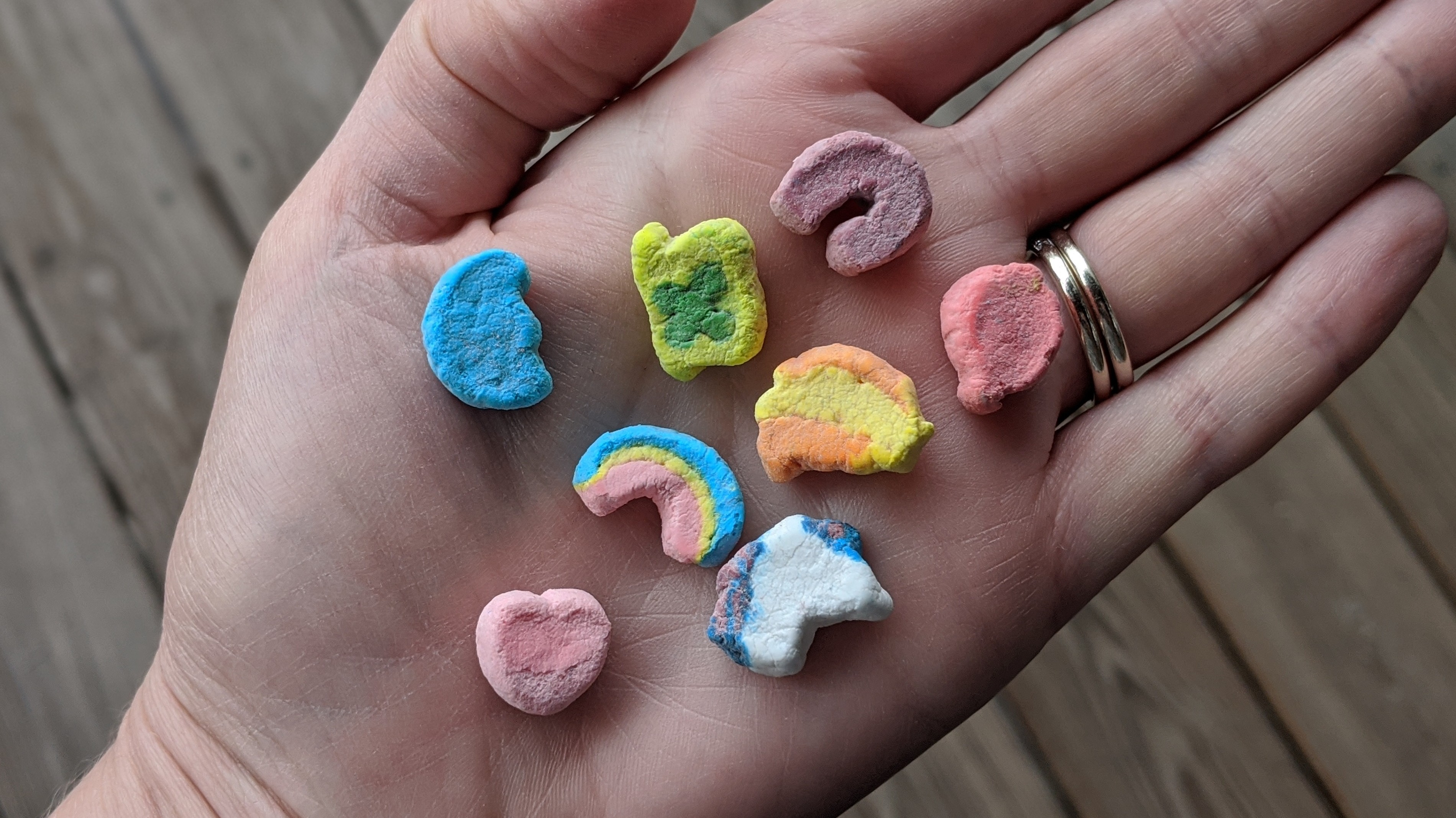 Eight Lucky Charms cereal marshmallows of every variety spread out on an open palm