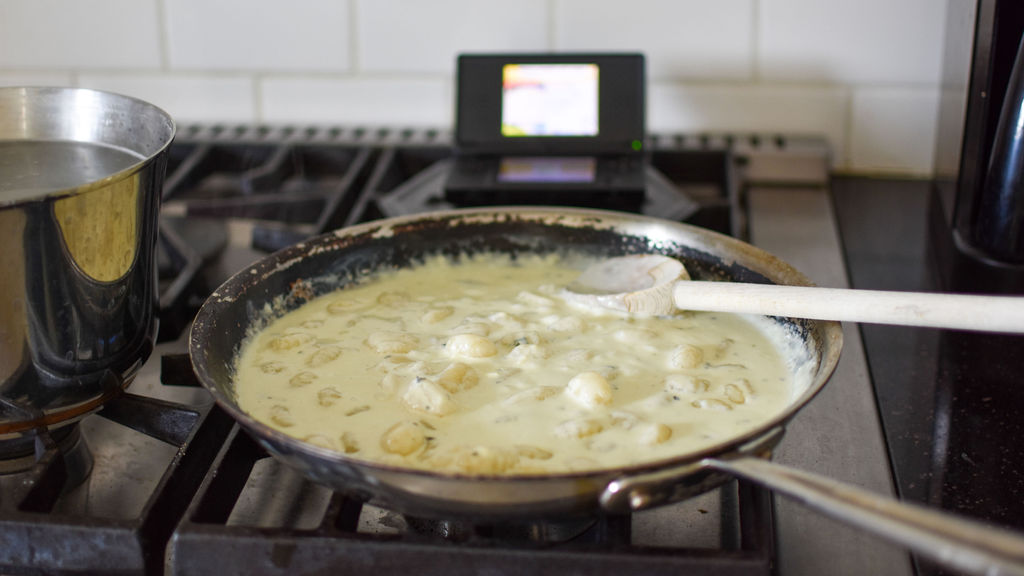 Saute pan on stovetop beside Nintendo DS