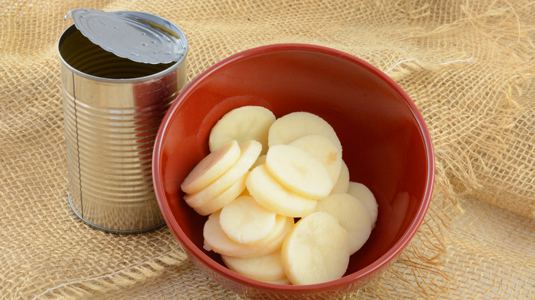 Sliced potato in a bowl next to an open can