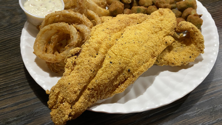 Fried catfish on a paper plate with other fried foods