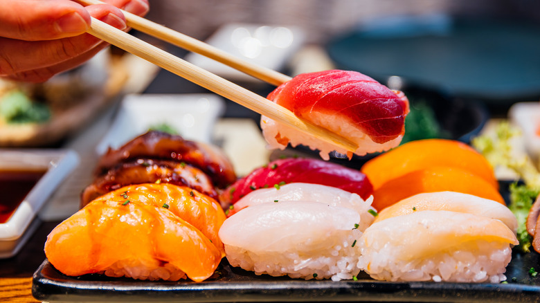 Chopsticks grabbing a piece of sushi