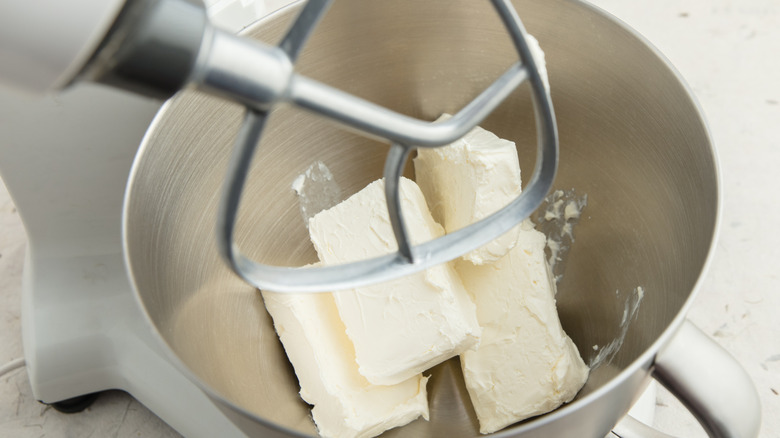 Blocks of cream cheese in a metal mixer