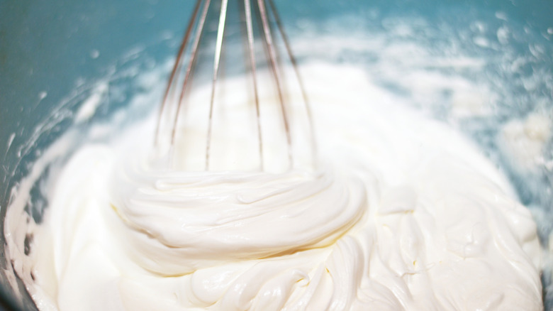 Whisk whipping cream in bowl