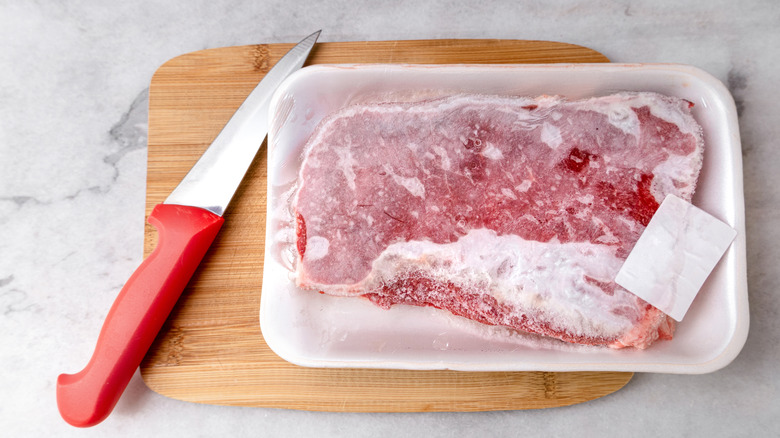 Frozen steak on a wooden board