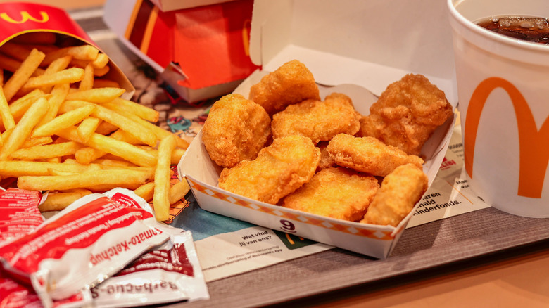 McDonald's food, with an open box of McNuggets, fries, and a soda