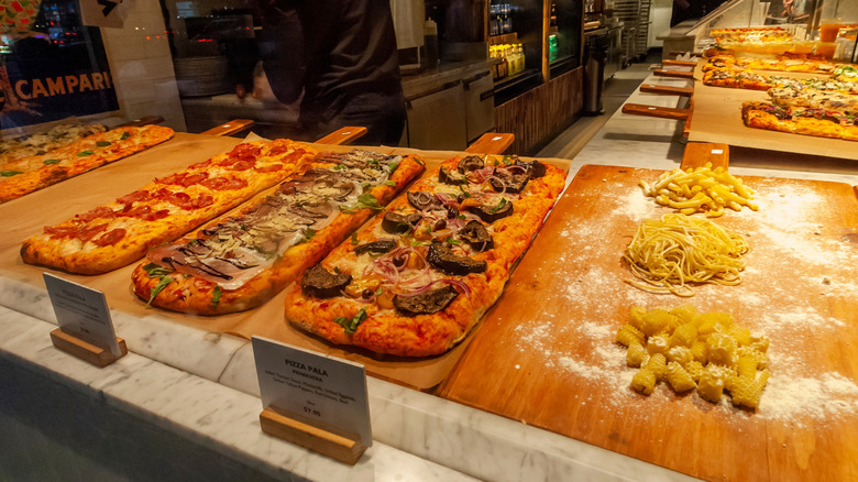 Pizzas on display behind glass