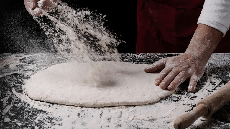 A chef making pizza dough