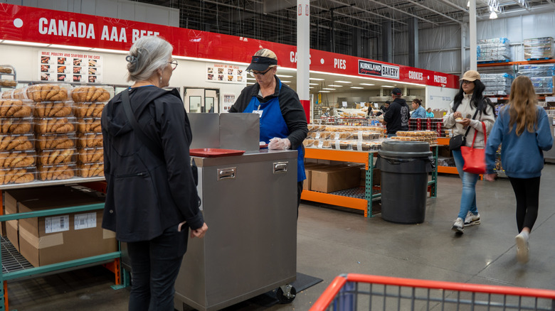 A customer gets a sample from an employee at Costco