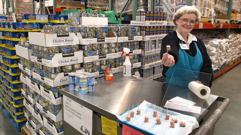 An employee holds out a small sample of Vienna sausage on a stick at Costco