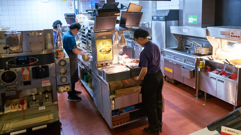 McDonald's workers in restaurant kitchen with the ice cream machine on the left