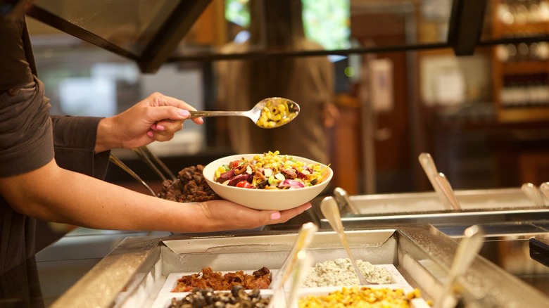 Customer getting food from the Sizzler salad bar