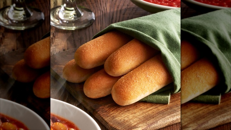 Five breadsticks from Olive Garden wrapped in a green napkin