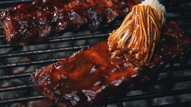 Ribs being brushed with BBQ sauce