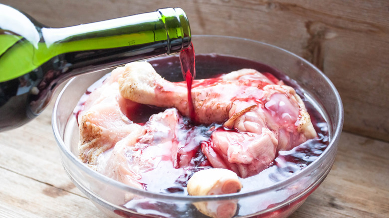 Red wine being poured onto chicken