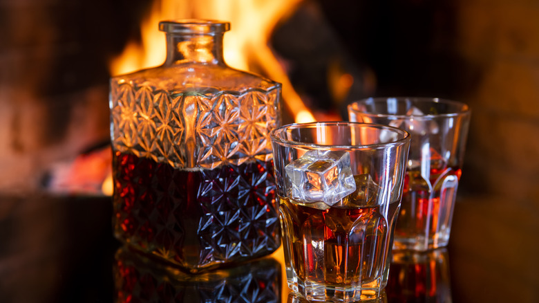 Ornate decanter of rum and partially filled glasses