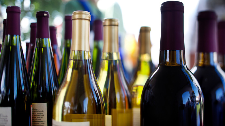 Several unopened red and white wine bottles