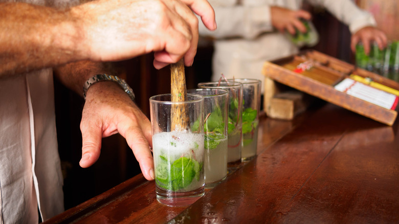 A bartender making mojitos