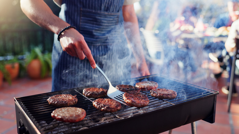 Person grilling burger patties