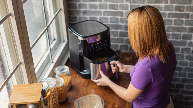 Woman using an air fryer