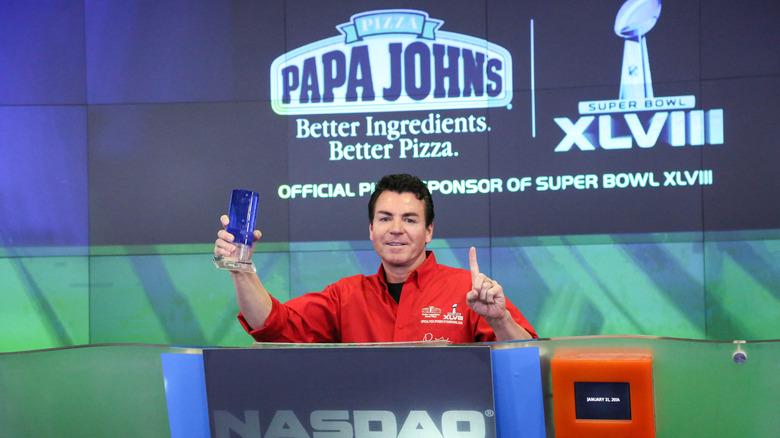 John Schnatter holding up an award at a podium