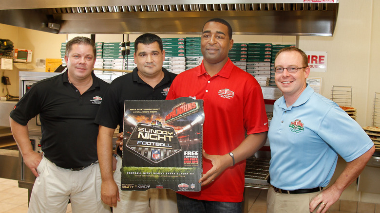 NFL star Cris Carter holds an NFL Papa Johns pizza box