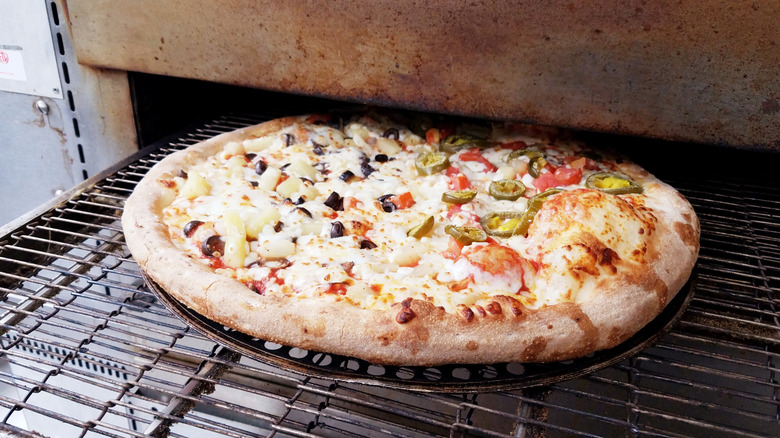 Pizza going into oven