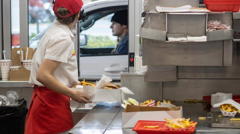 In-N-Out worker serves food at the drive-thru window