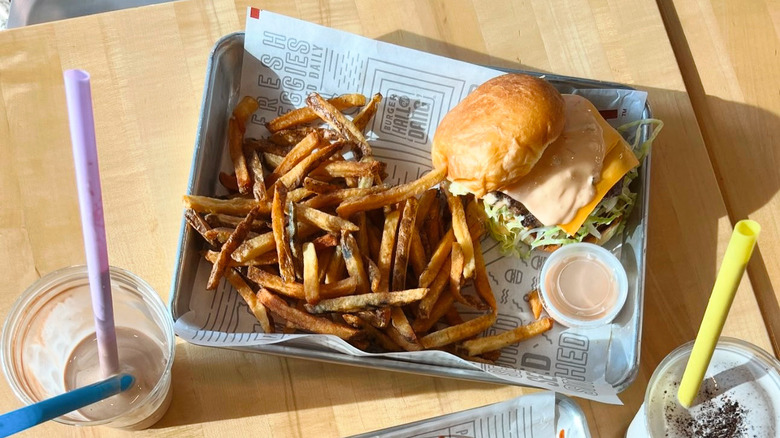 Mooyah's burger and fries on a tray next to a shake