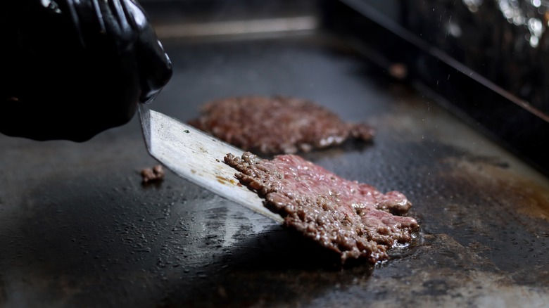 Flipping smash burger patty with a spatula