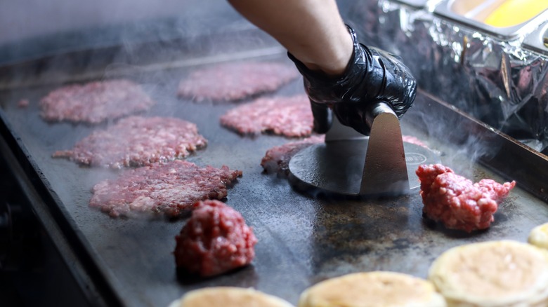 Person smashing smash burger balls