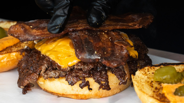 Person assembling a smash burger