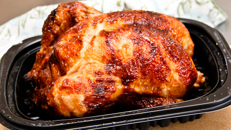 Golden brown rotisserie chicken in black tray