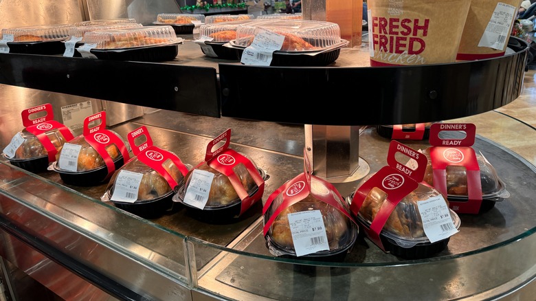 Rotisserie chickens on display under heating lamp