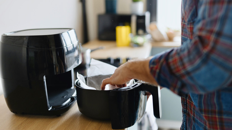 Person putting paper in air fryer