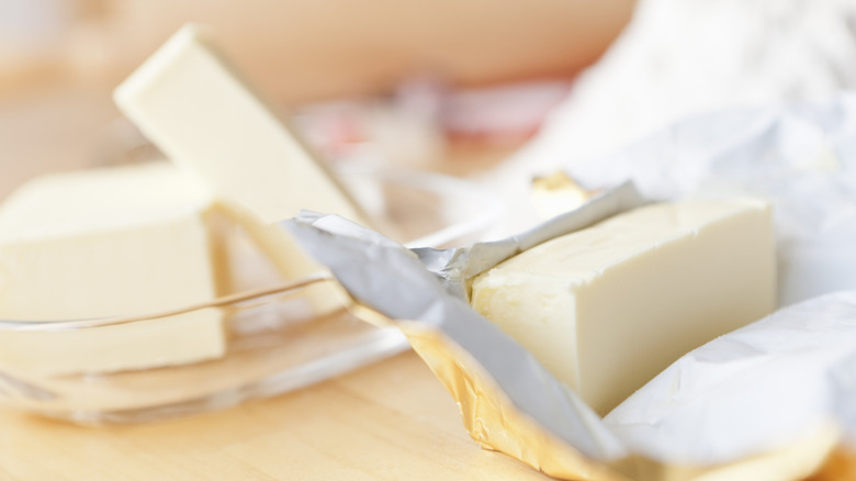 Butter in a wrapper next to butter in a dish