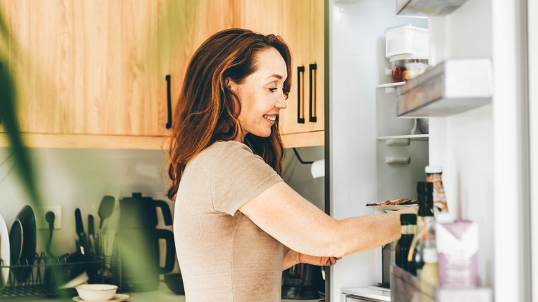 Person looking into open fridge