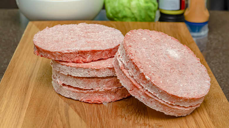 Frozen burgers on a cutting board