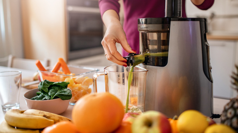 Person using juicer in kitchen