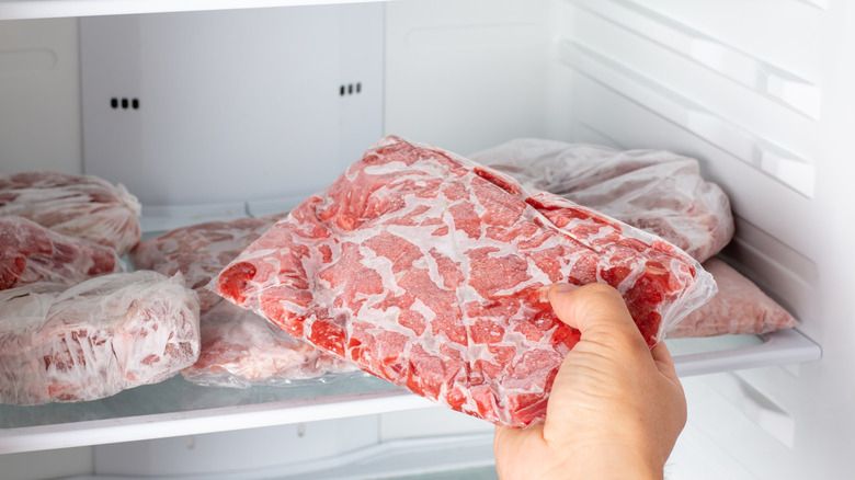 Man taking out frozen ground beef out of the freezer